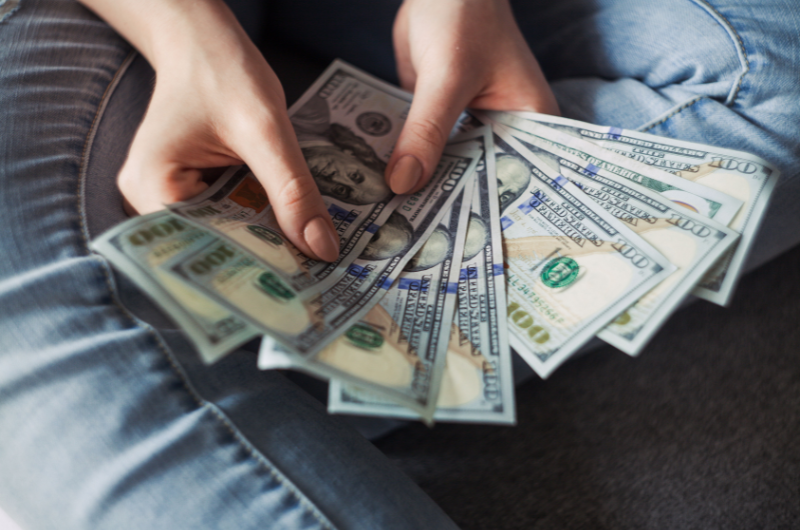 Notas de dólar representando custos ocultos em viagens para os EUA