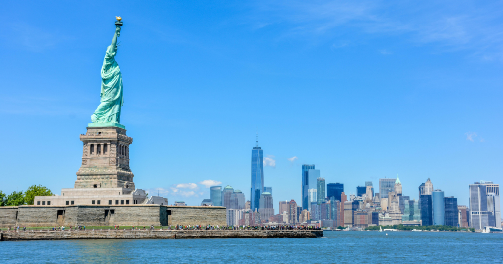 Por que brasileiro paga mais caro nos EUA - Estátua da Liberdade com skyline de Manhattan ao fundo